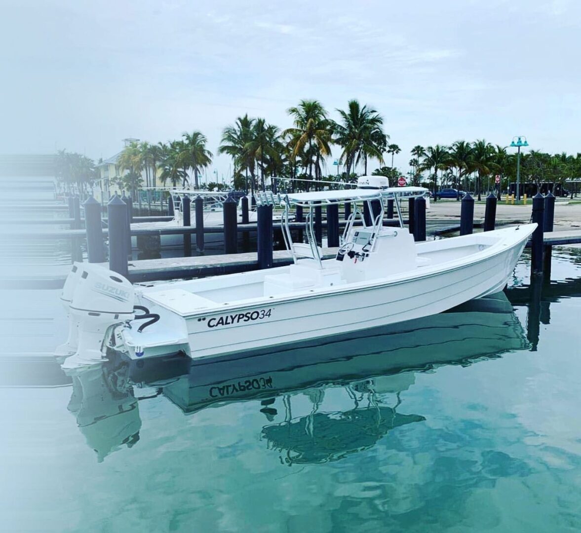 A white boat is docked in the water.