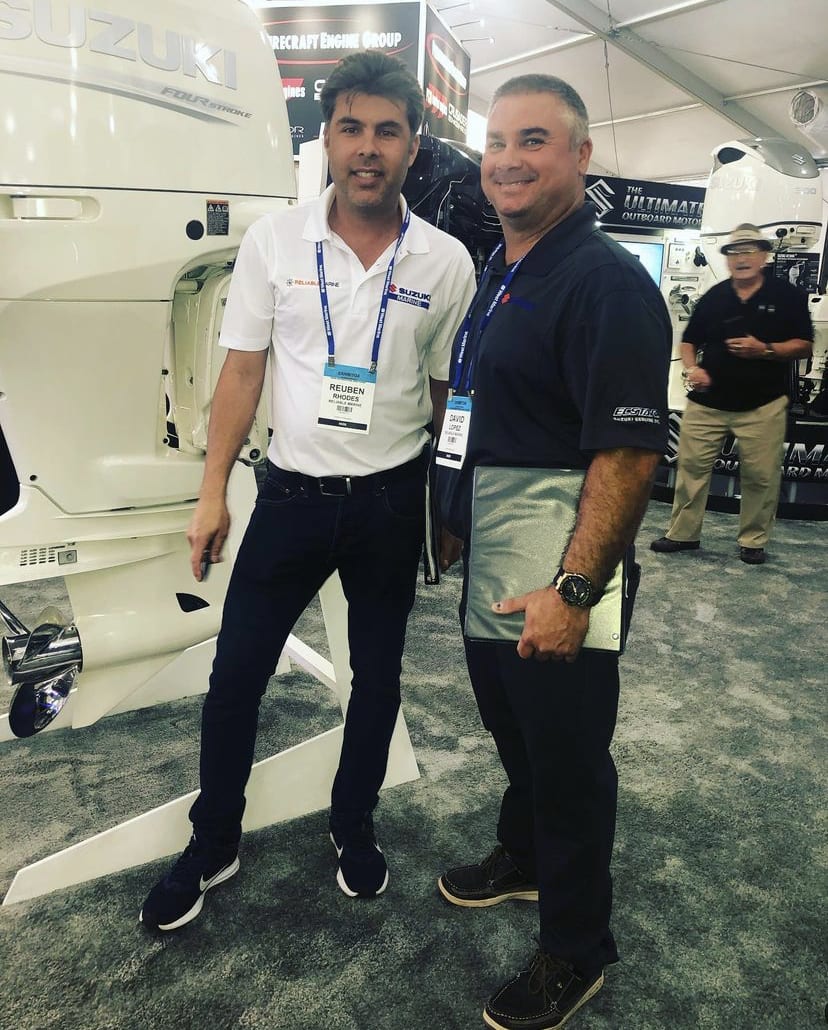 Two men standing next to each other in front of a white toilet.