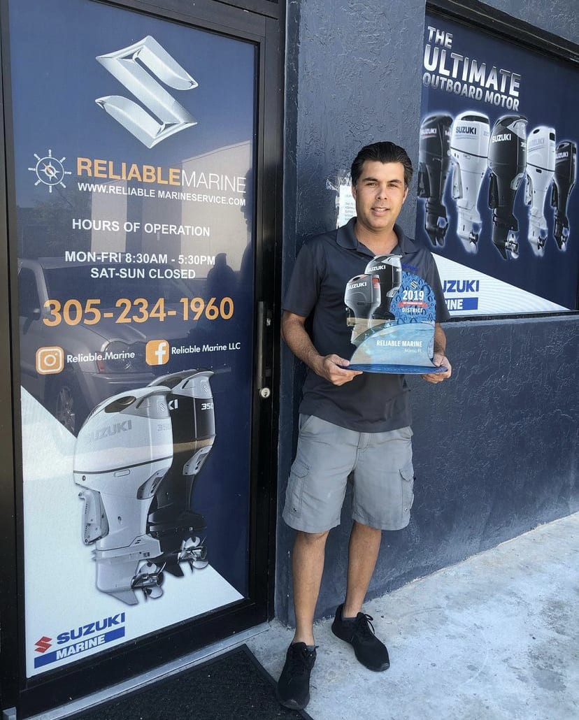 A man holding a box standing in front of a store.